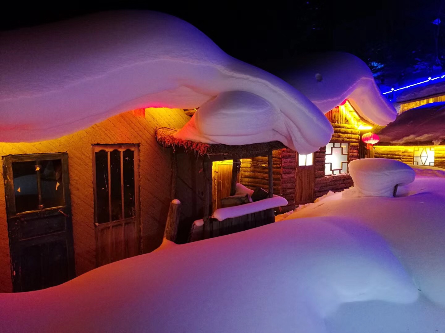 白天的雪花落在屋顶上,积累的厚厚的一层,十分的漂亮,但是夜晚的雪村